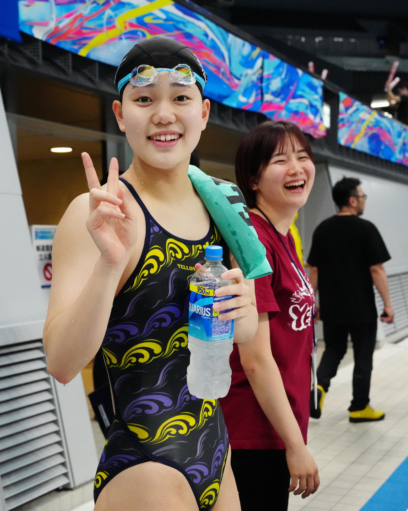 パリ五輪代表選考会の女子100メートルバタフライ決勝前の練習を終えた平井はピースサインを見せる（撮影・江口和貴）