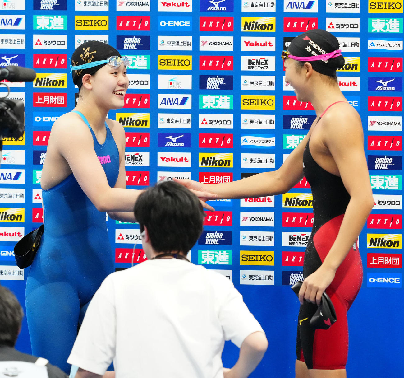 パリ五輪代表選考会の女子100メートルバタフライ決勝後、握手を交わす平井（左）と池江（撮影・江口和貴）