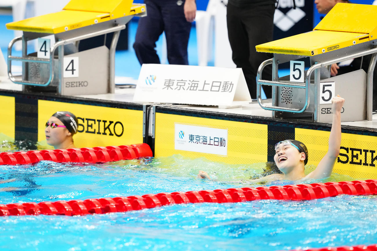 パリ五輪代表選考会の女子100メートルバタフライ決勝で派遣標準記録に届き、ガッツポーズを見せる平井（右）。左は池江（撮影・江口和貴）