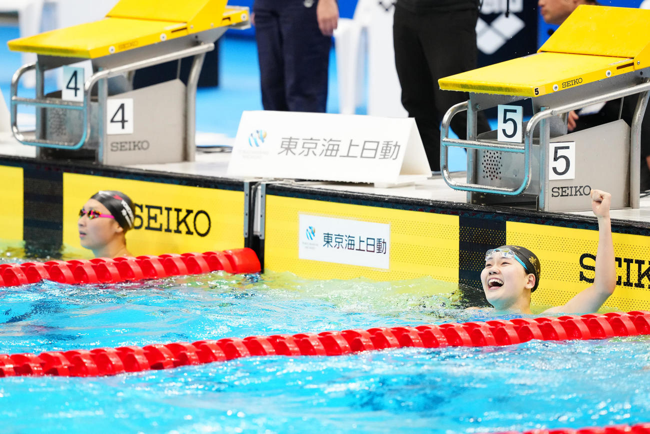 女子100メートルバタフライ決勝で派遣標準記録に届き、ガッツポーズを見せる平井（右）。左は池江（撮影・江口和貴）