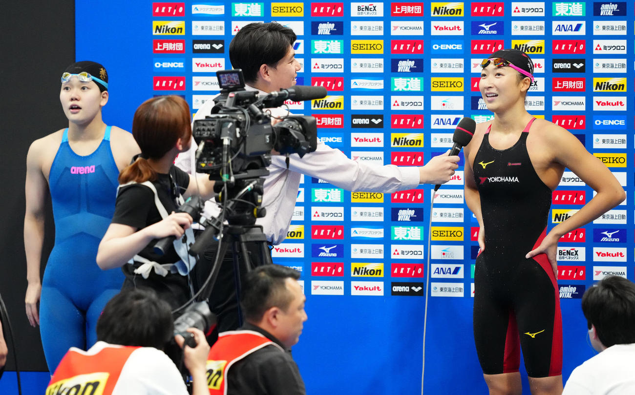 パリ五輪代表選考会の女子100メートルバタフライ決勝で派遣標準記録に届き、インタビューを受ける池江（右）。左は平井（撮影・江口和貴）