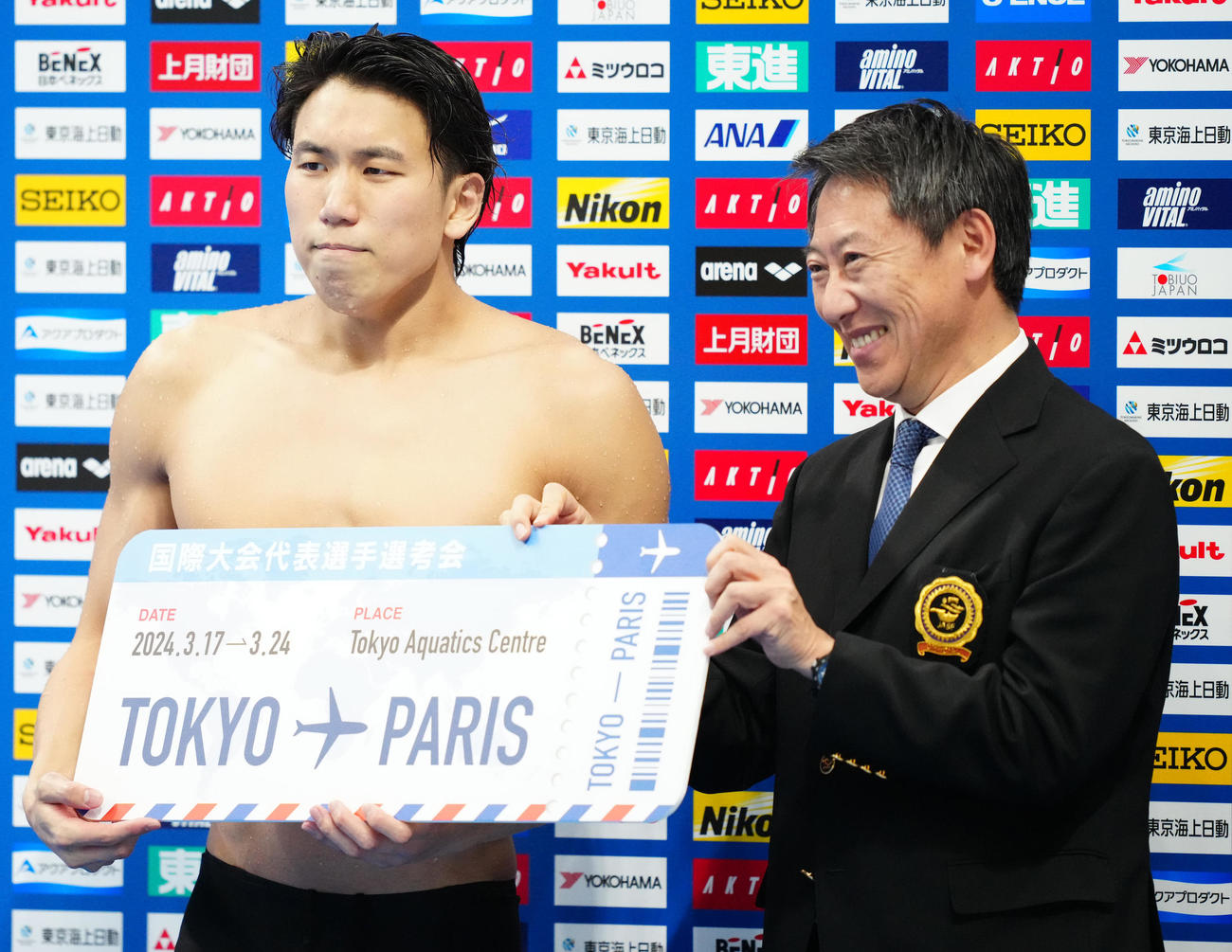 パリ五輪代表選考会の男子200メートル自由形決勝で派遣標準記録に届き、日本水泳連盟鈴木会長（右）と写真に納まる松元（撮影・江口和貴）