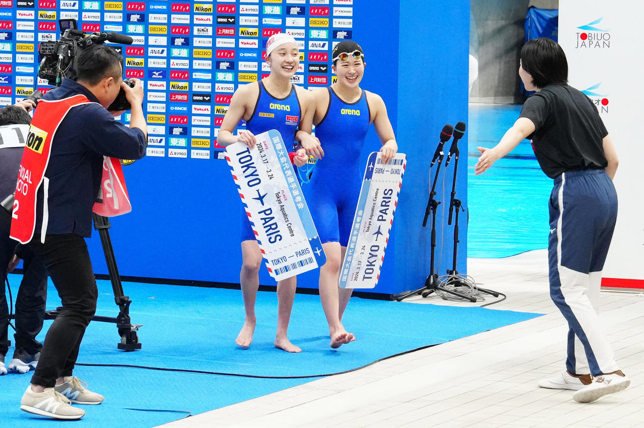 パリ五輪代表選考会の女子400メートル個人メドレー決勝後、腕を組む成田（中央左）と谷川（撮影・江口和貴）