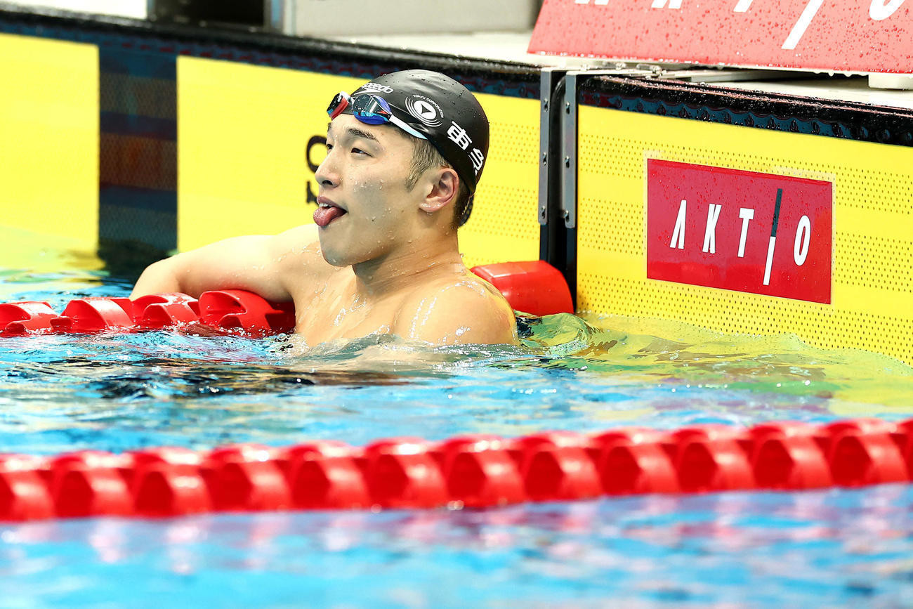 男子200メートル平泳ぎ準決勝終え、舌を出しながらタイムを確認する深沢（撮影・河田真司）
