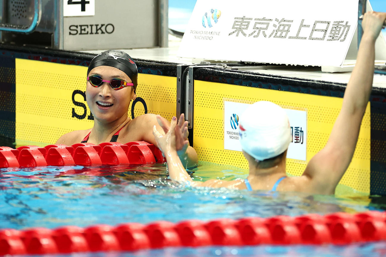 女子100メートル自由形準決勝を終え、神野（右）と握手を交わす池江（撮影・河田真司）