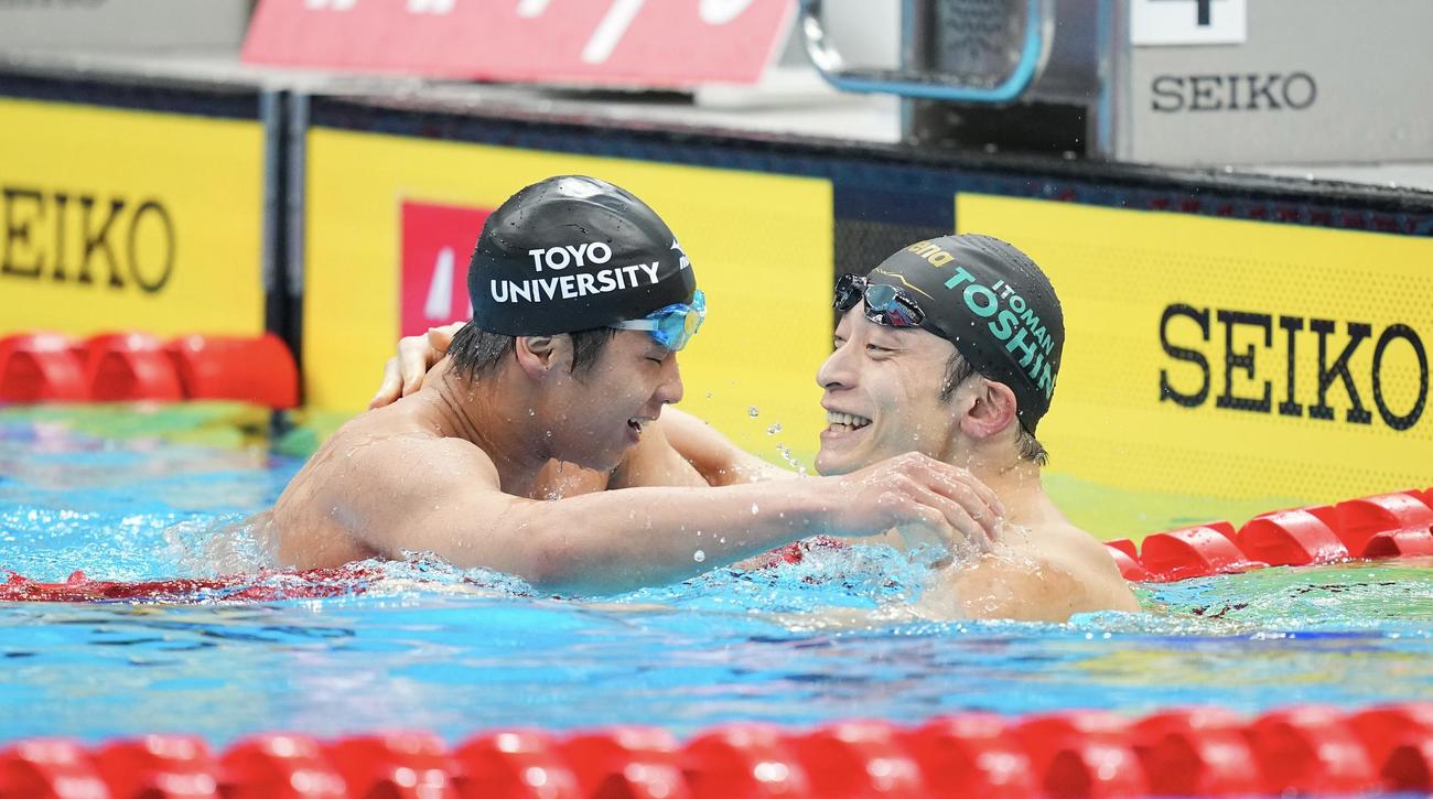 男子100メートル背泳ぎ決勝、1位で代表を決めた竹原（左）は入江と健闘をたたえ合い感極まる（撮影・垰建太）
