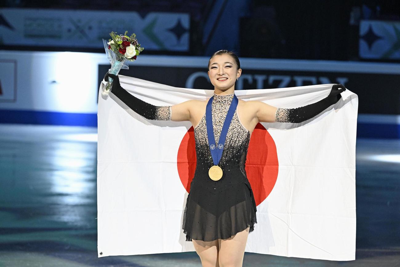 世界選手権の女子で56年ぶりとなる3連覇を果たし、日の丸を掲げる坂本（共同）