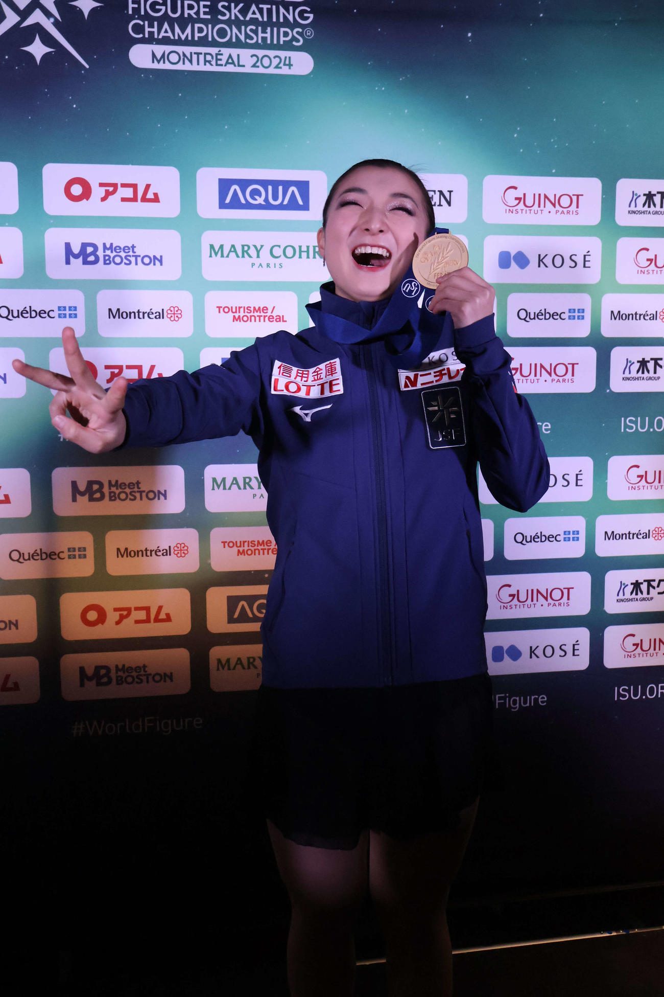 3連覇を飾った坂本花織は会見後に三本指を立てて笑顔でポーズ