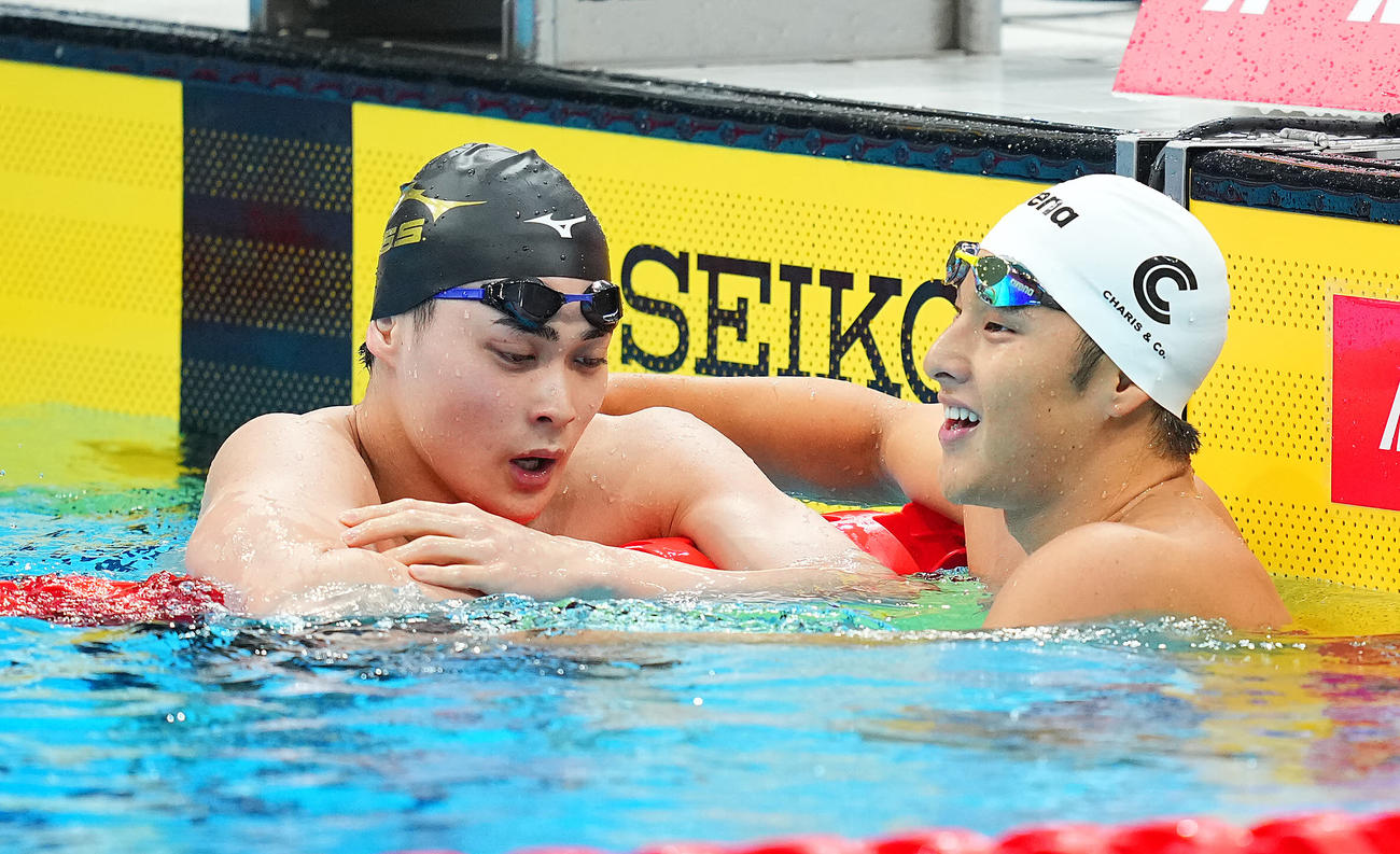 男子200メートル個人メドレー決勝のレース後に悔しげな表情を見せながらも小方（左）は瀬戸と健闘をたたえ合う（撮影・垰建太）