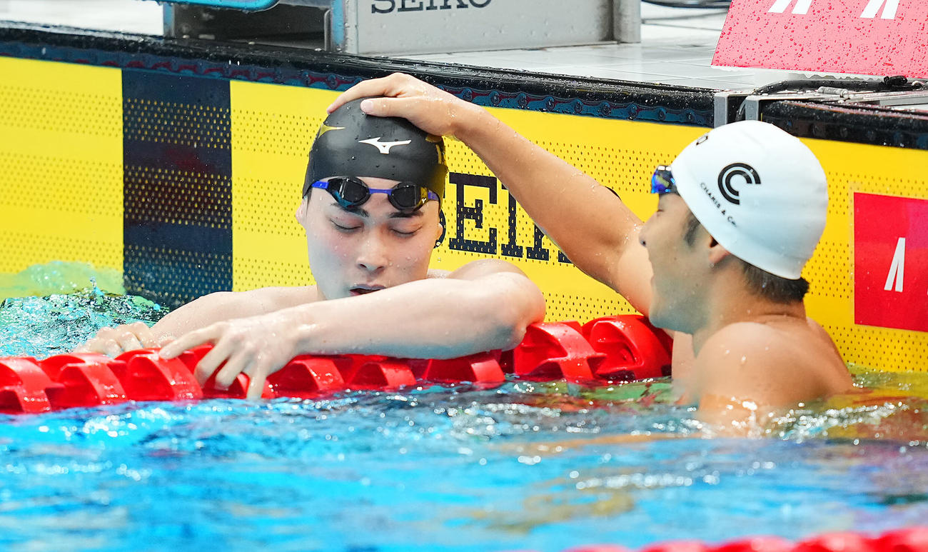 男子200メートル個人メドレー決勝のレース後に悔しげな表情を見せながらも小方（左）は瀬戸と健闘をたたえ合う（撮影・垰建太）