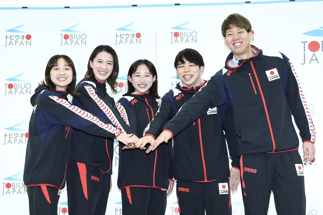手を合わせ笑顔で写真に納まるパリ五輪競泳代表選手たち。左から成田、大橋、三井、寺門、渡辺（撮影・河田真司）