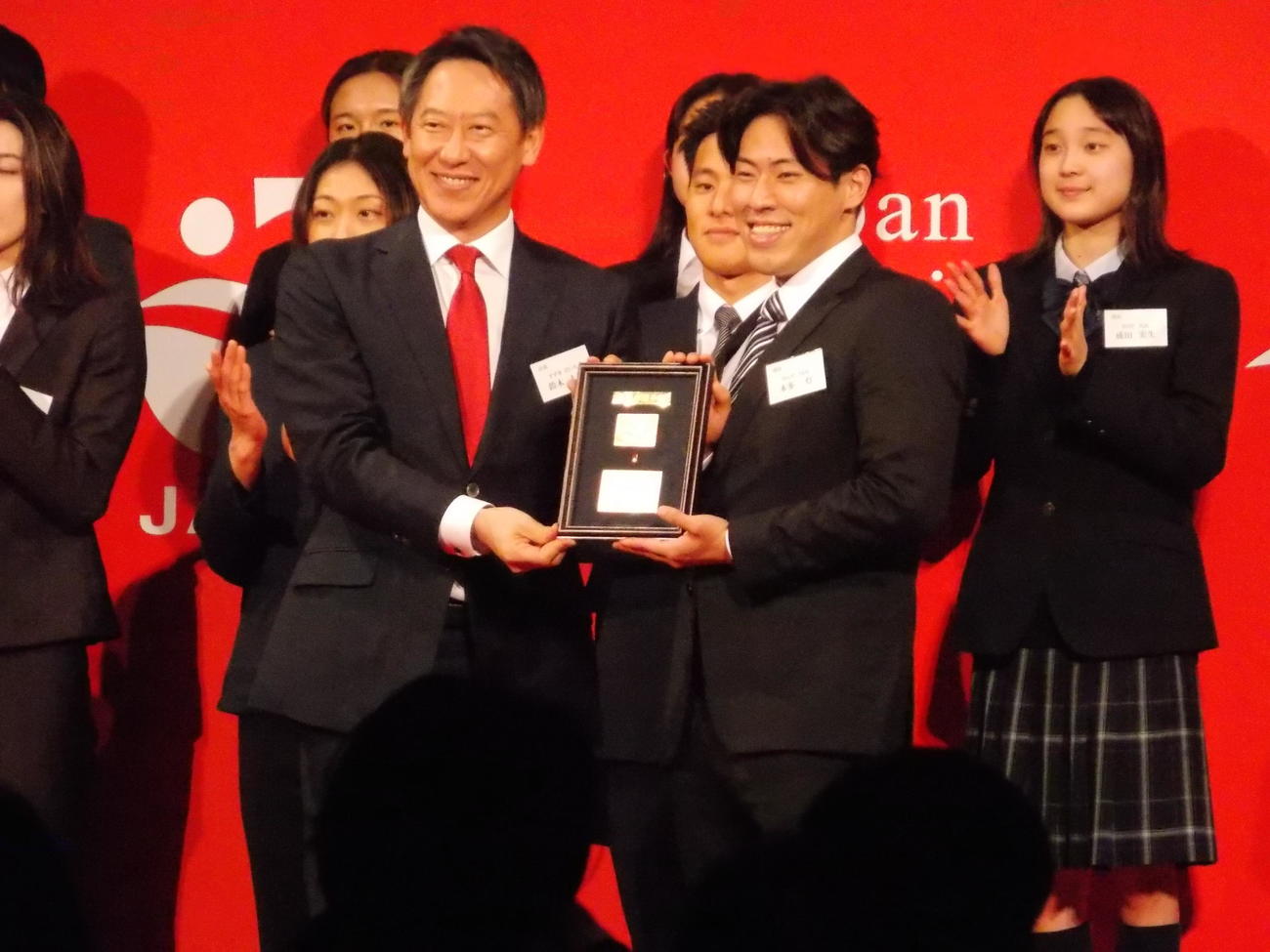 最優秀選手賞を受け取った本多（前列右）と鈴木会長（同左）（撮影・松本航）