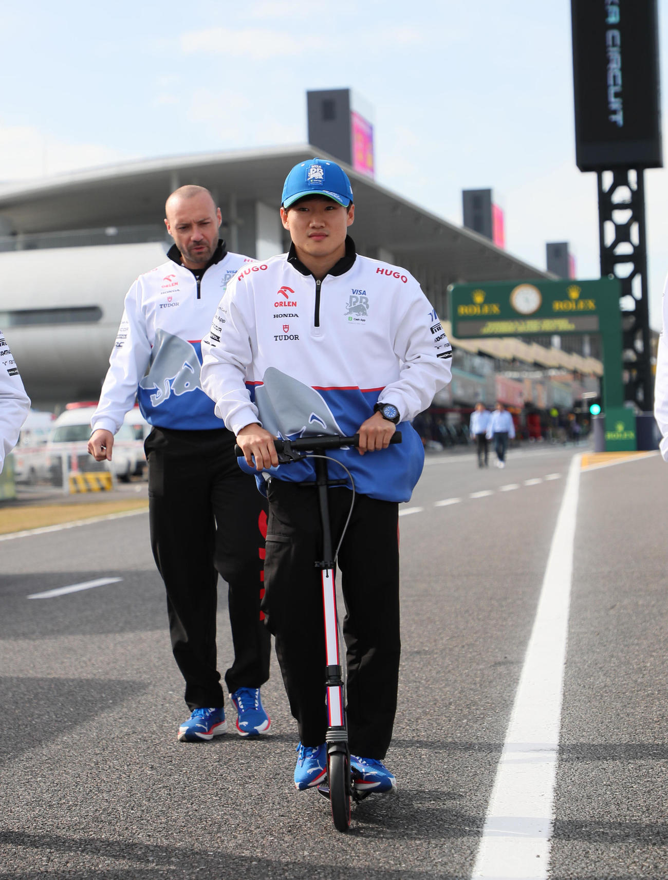 F1日本GPが開幕し、キックボードに乗りコースチェックをするRBの角田裕毅（撮影・宮崎幸一）