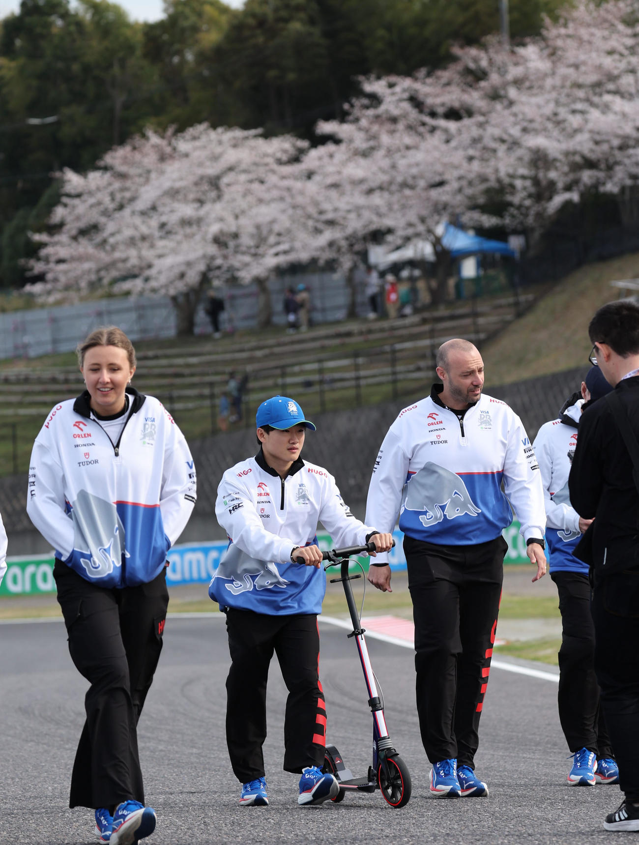 F1日本GPが開幕し、S字コーナーに咲く桜をバックにコースチェックをするRBの角田裕毅（撮影・宮崎幸一）