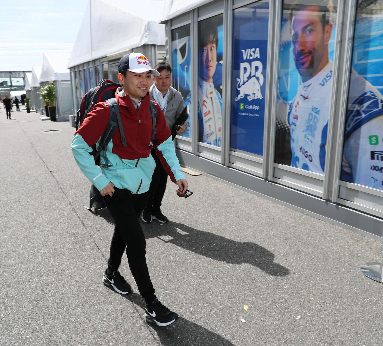 RBでのFP1出走に向け、正規ドライバーの角田裕毅（左）とリカルドの写真が貼り出されたホスピタリティブースに到着した岩佐歩夢（撮影・宮崎幸一）