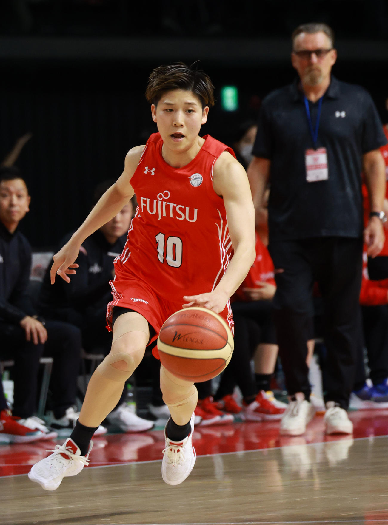 富士通対デンソー　第3クオーター、華麗なドリブルを見せる富士通・町田。後方はBT・テーブスヘッドコーチ（撮影・中島郁夫）