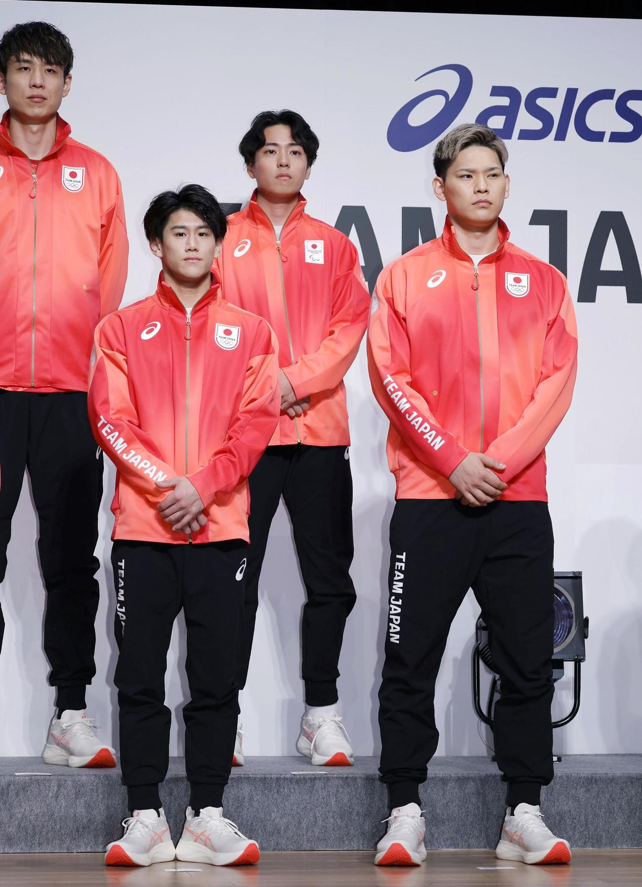 パリ五輪とパラリンピックの日本選手団の公式スポーツウエアをお披露目する体操の橋本大輝（手前左）、バレーボールの西田有志（同右）ら（共同）