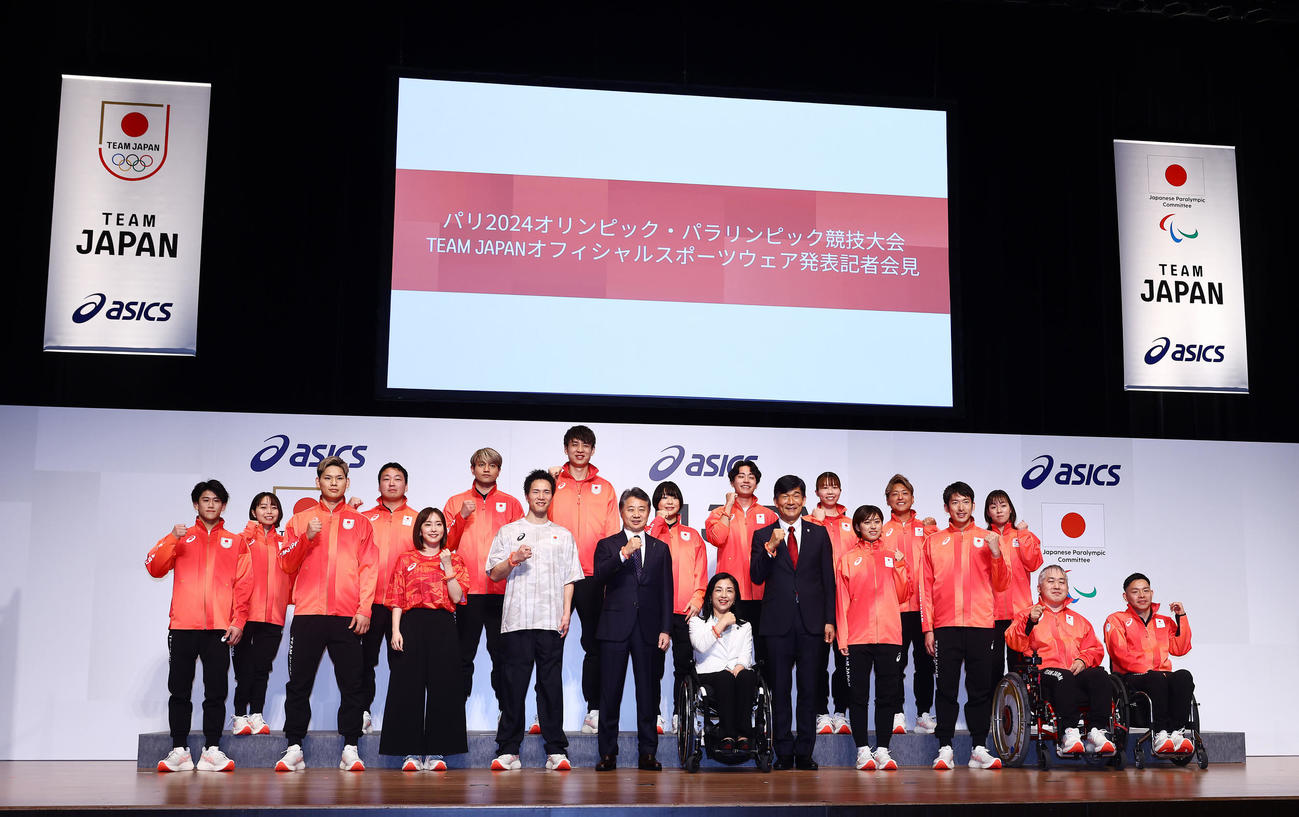 日本代表オフィシャルスポーツウェアを着て写真に納まる五輪、パラリンピックの選手ら。前列左から橋本、西田有、石川さん、鳥海、アシックス富永満之代表取締役社長、パラリンピック日本代表選手団田口団長、五輪TEAM JAPAN尾縣団長、竹村、見延、広瀬、若山、後列左から西田杏、新保、東江、小野寺、藤浪、田巻、東藤、宇田、木下（撮影・垰建太）