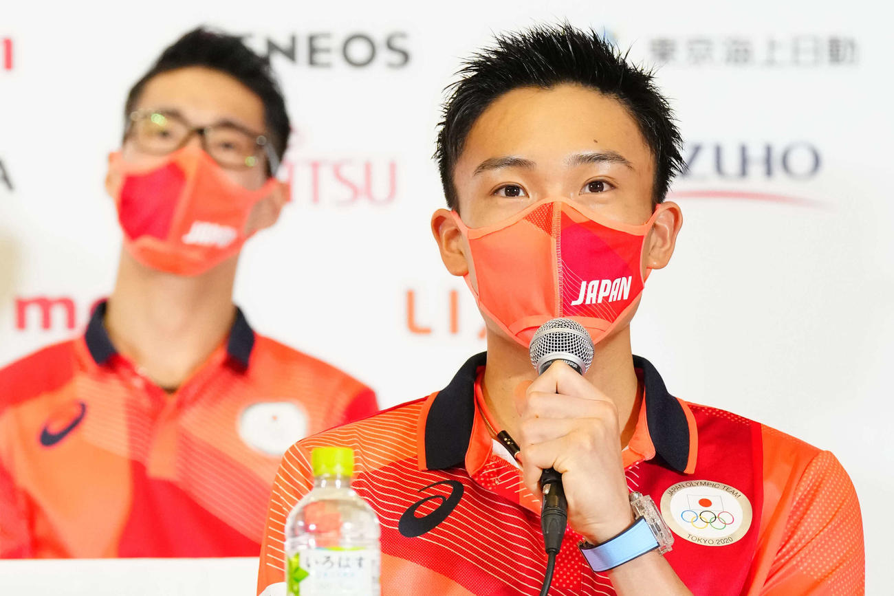 東京五輪日本選手団の入村会見で質問に答える桃田。後方は常山（2021年7月18日）
