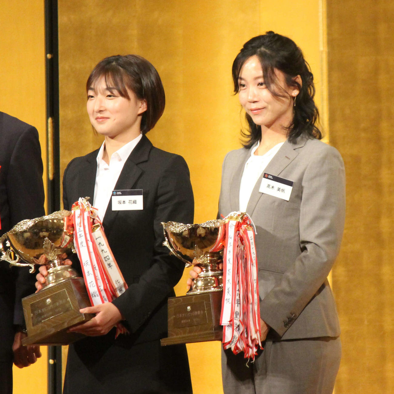 シーズン表彰祝賀会でJOC杯を手にする坂本花織（左）と高木美帆（撮影・勝部晃多）