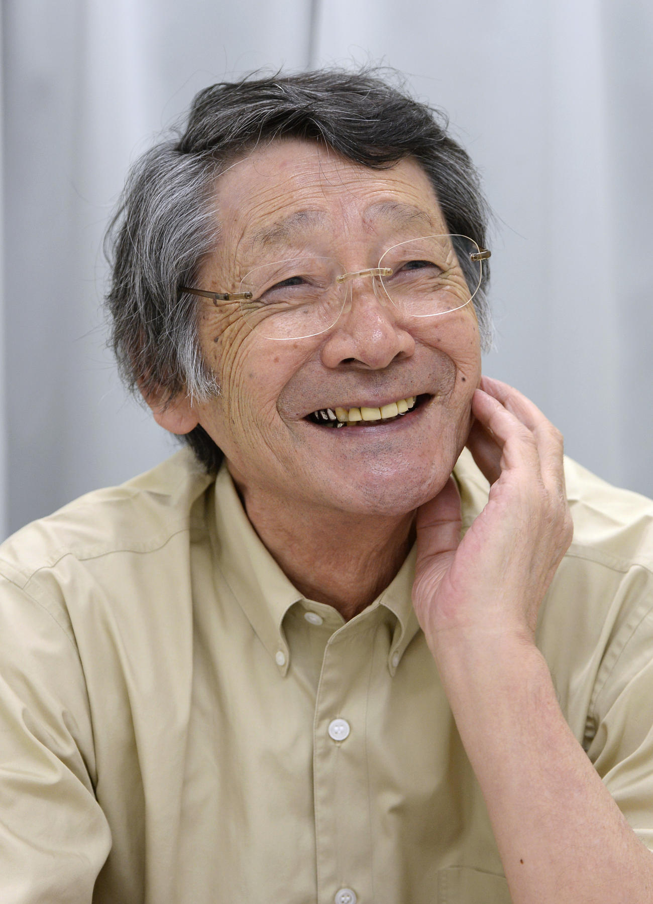 笑顔でインタビューに答える笠谷幸生さん（2013年8月、共同）