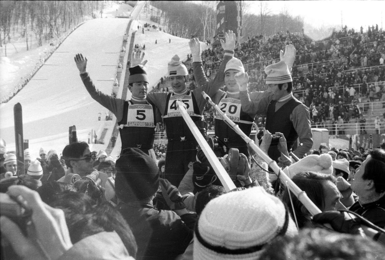 札幌五輪70メートル級ジャンプ　メダル独占の快挙に。2万5000の観衆に応える日の丸飛行隊。左から銀メダル金野氏、金メダル笠谷氏、銅メダル青地氏、2本目失敗で23位となった藤沢隆氏