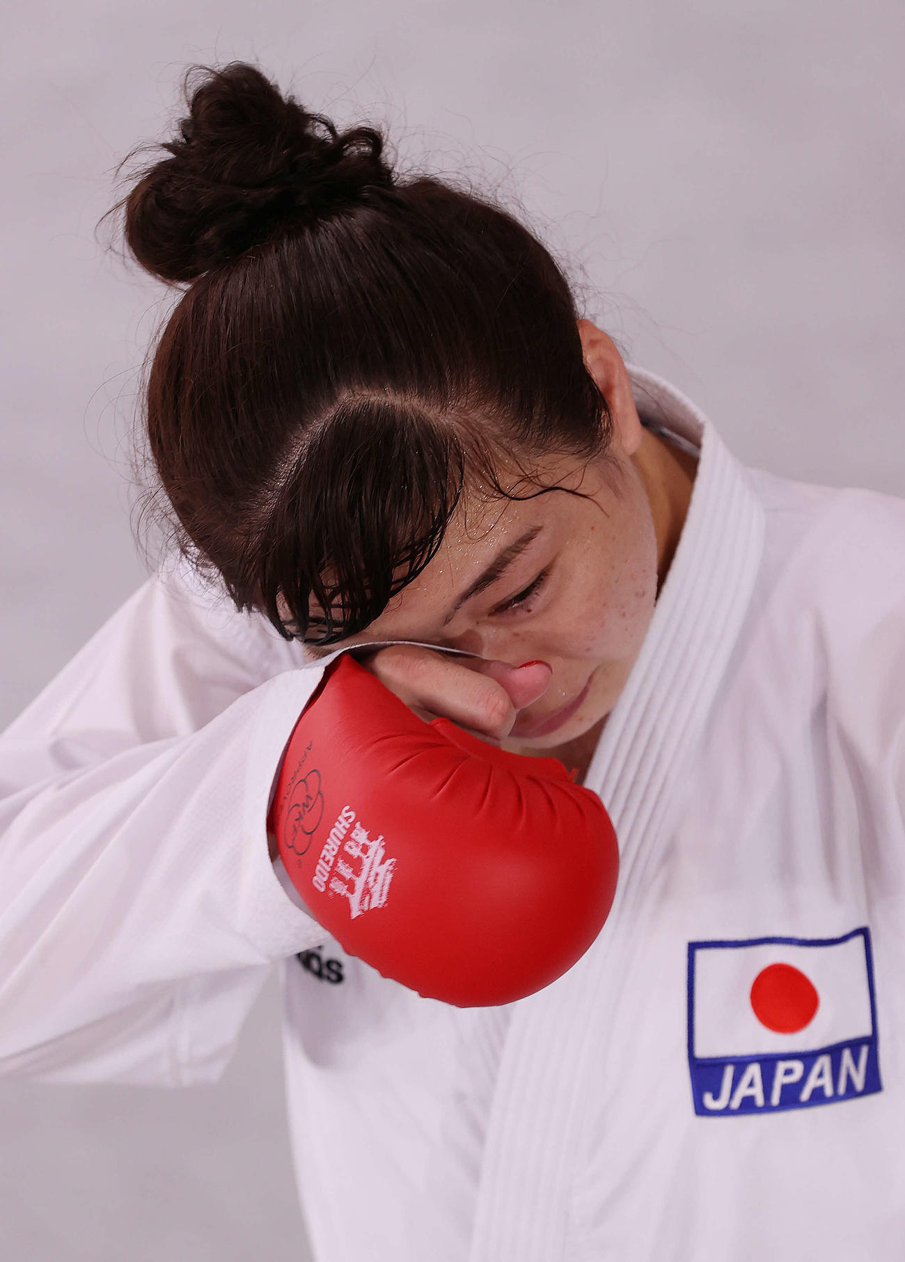 東京五輪の空手女子組手61キロ超級で1次リーグ敗退となり涙を拭いながら引き揚げる植草（2021年8月7日）