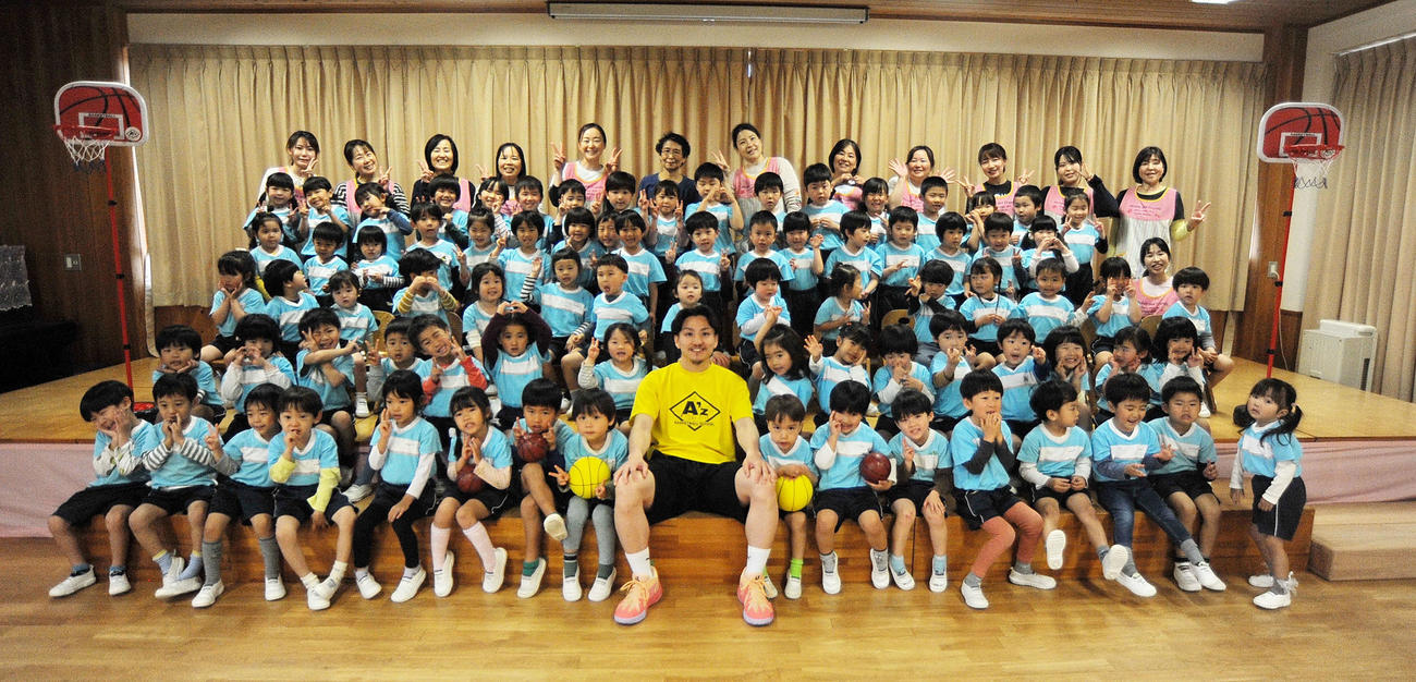 4月23日、さくら幼稚園の園児や関係者と記念写真に納まる大沢氏（前列中央）