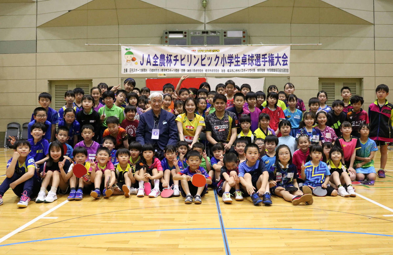 小学生に囲まれ写真に納まる石川佳純さん（中央）