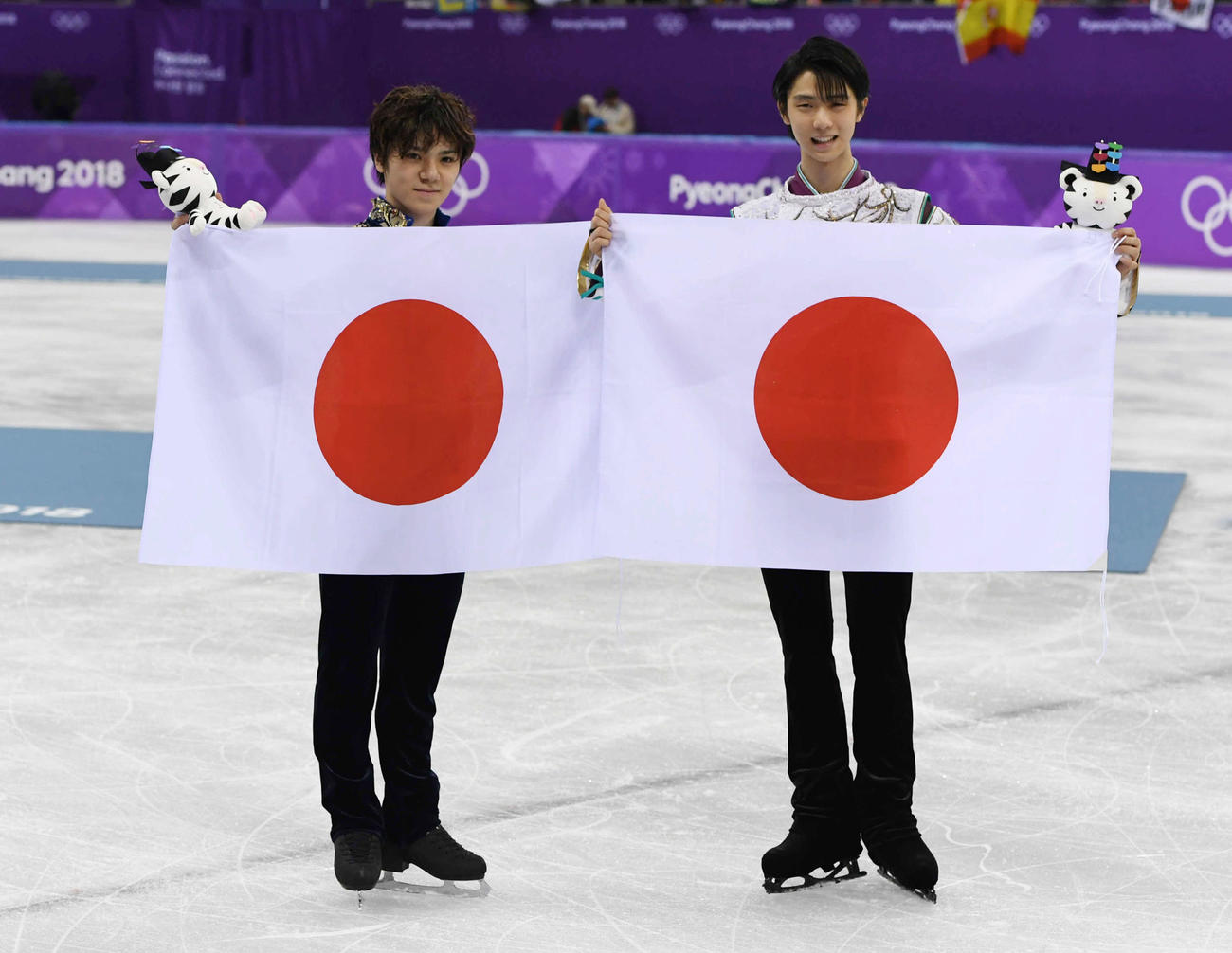 2018年2月　金メダルに輝いた羽生（右）と銀メダルの宇野は日の丸を掲げて笑顔を見せる