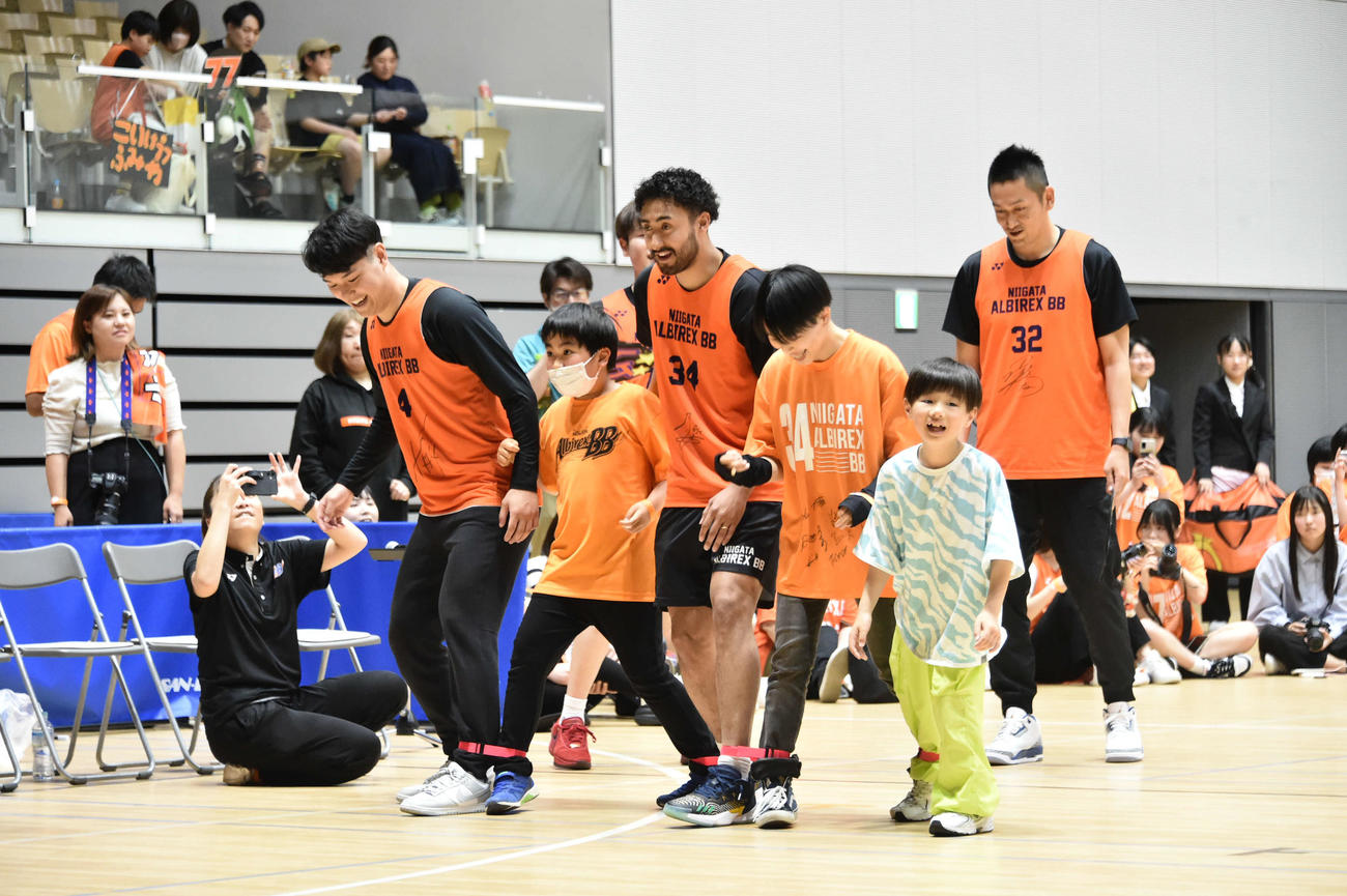子どもたちと5人6脚リレーを楽しむ新潟のメンバー。左から高橋、遠藤、池田