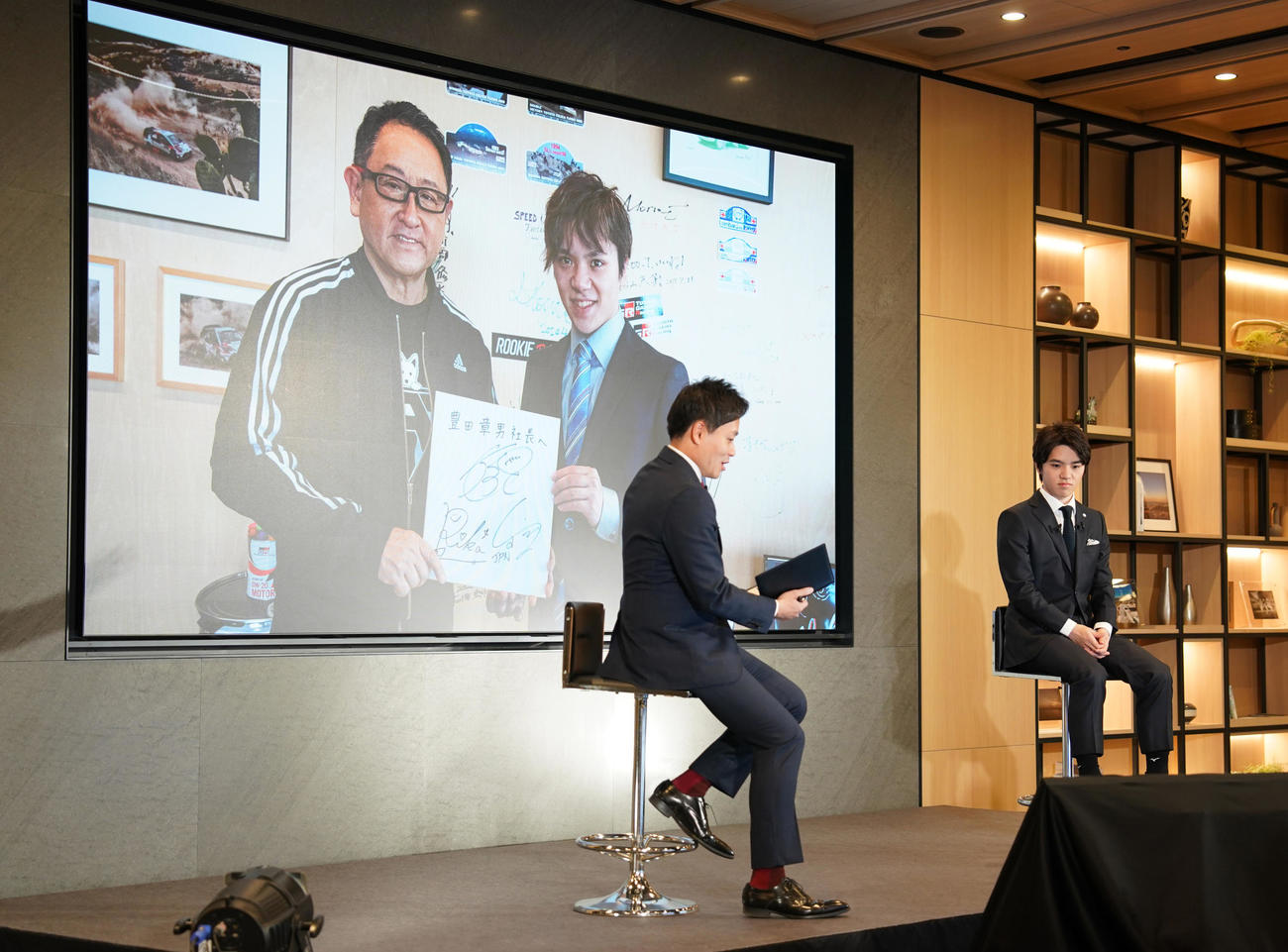引退会見を行った宇野（右）。後ろはトヨタ自動車の豊田章男会長との写真（撮影・鈴木みどり）