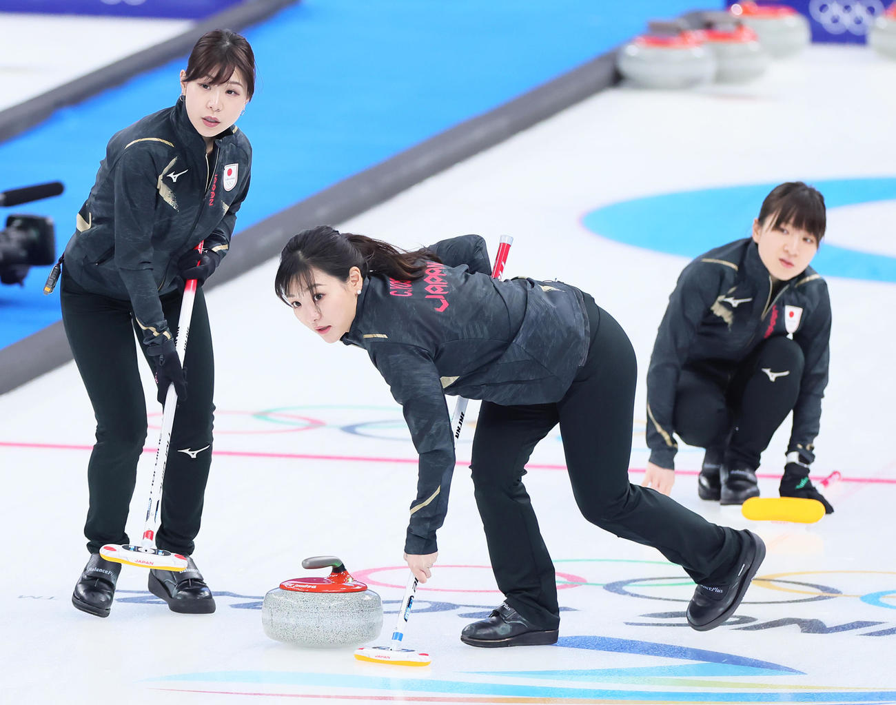 2022年2月12日、北京五輪　カーリング女子1次ぎリーグ　日本対デンマーク　スイープする吉田夕梨花（左）と吉田知那美。右は鈴木夕湖