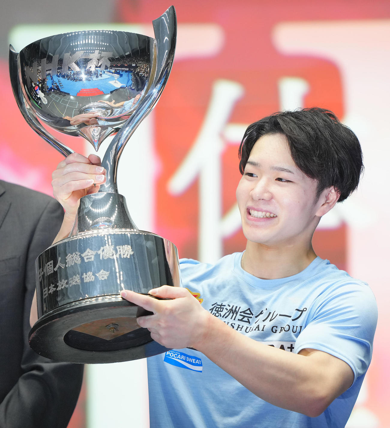 鉄棒の演技を終え優勝を決めた岡はトロフィーを手に笑顔を見せる（撮影・垰建太）