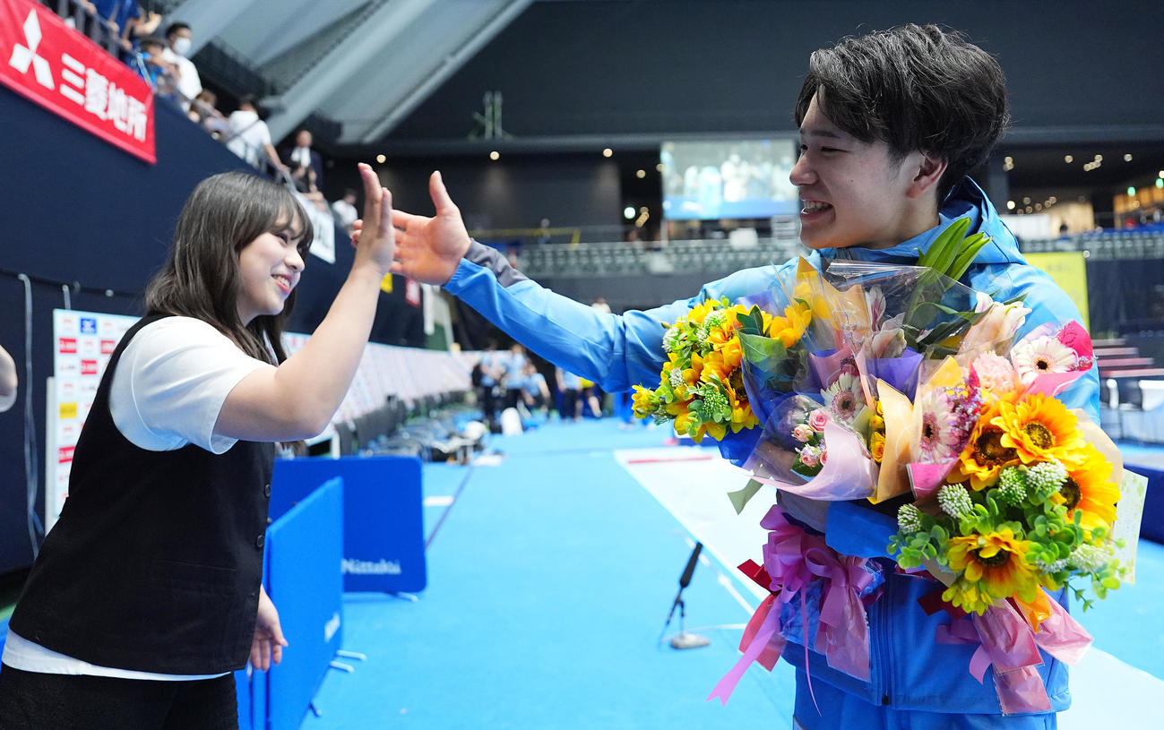 男子個人総合2日目、優勝した岡（右）は村上さんとタッチを交わし笑顔を見せる（撮影・垰建太）
