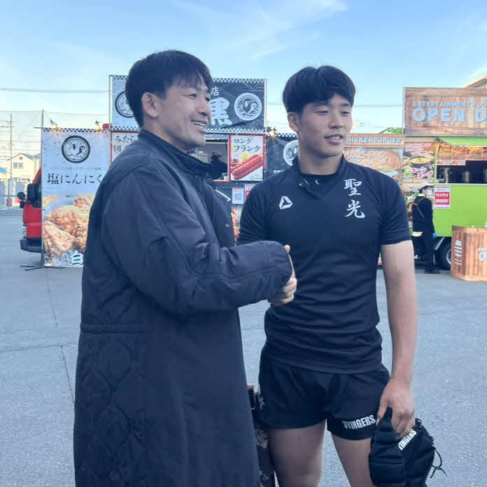 父の小野沢宏時氏と握手する、小野沢謙真（2023年12月30日撮影）