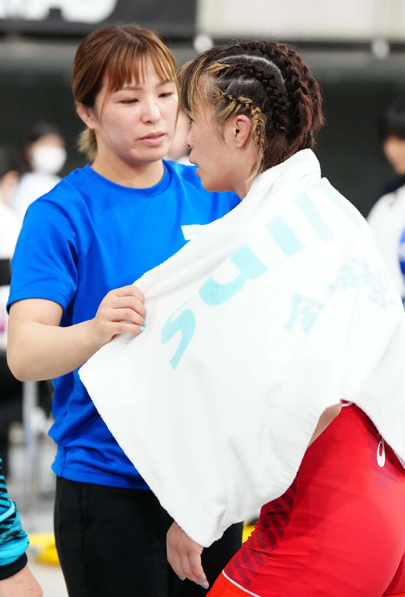 女子59キロ級準決勝　金城梨紗子対尾西桜　敗戦後、妹の恒村友香子（左）からタオルをかけられた金城梨紗子（撮影・江口和貴）