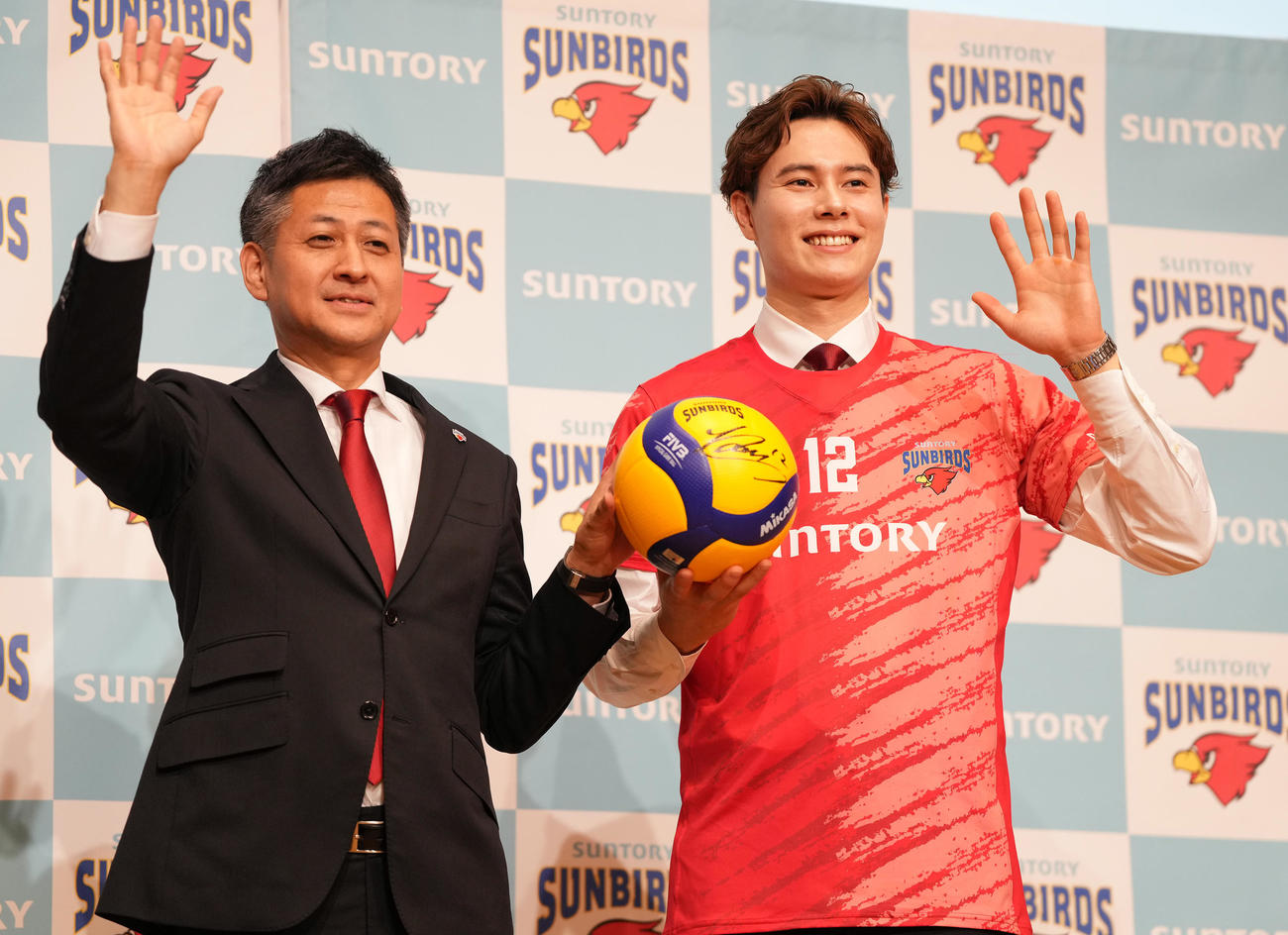 入団会見で栗原圭介GM（左）と手を振るサントリーの高橋藍（撮影・鈴木みどり）