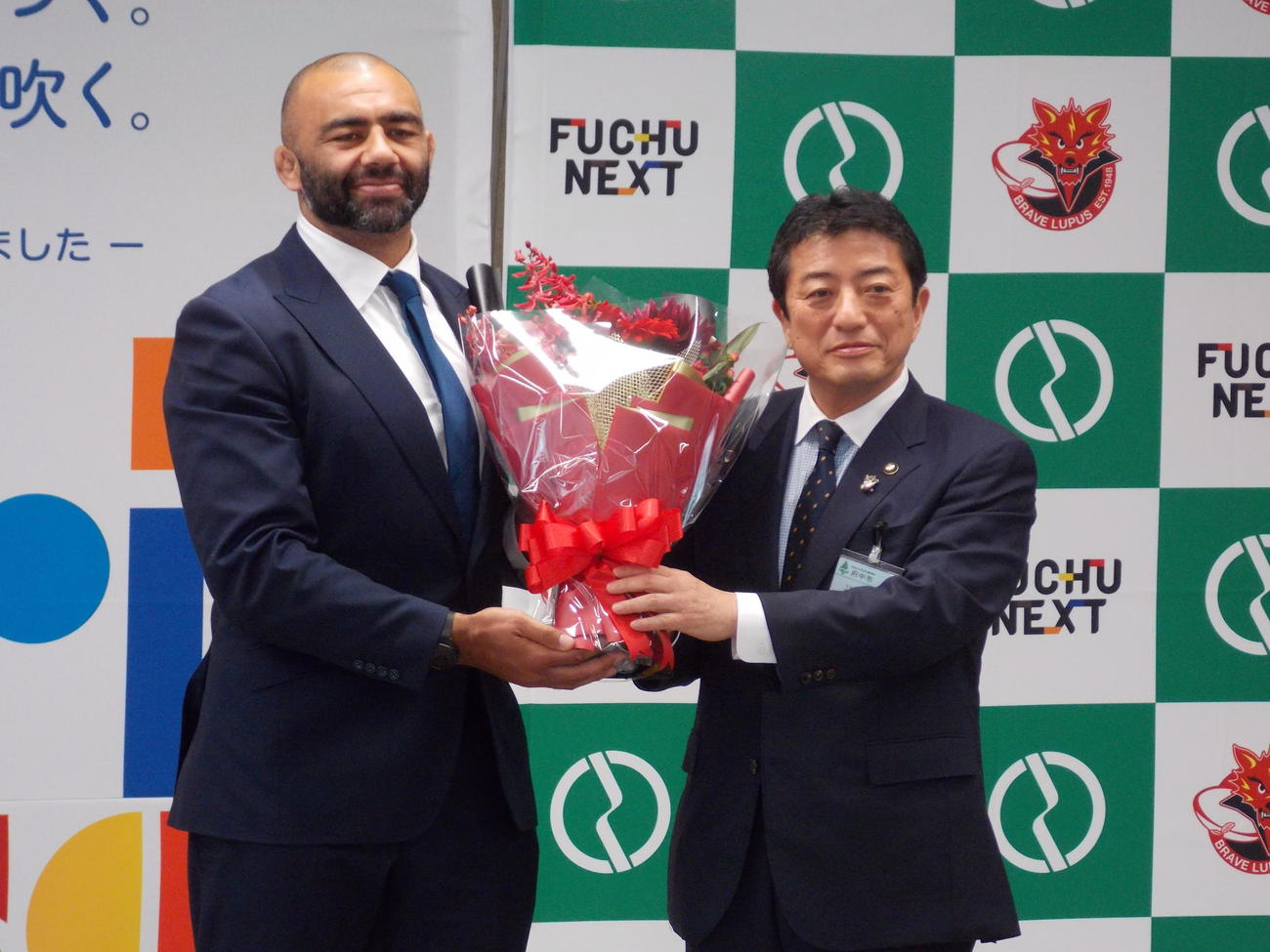 府中市役所を表敬訪問し、高野律雄市長（右）から花束を受け取ったBL東京リーチ・マイケル（撮影・松本航）