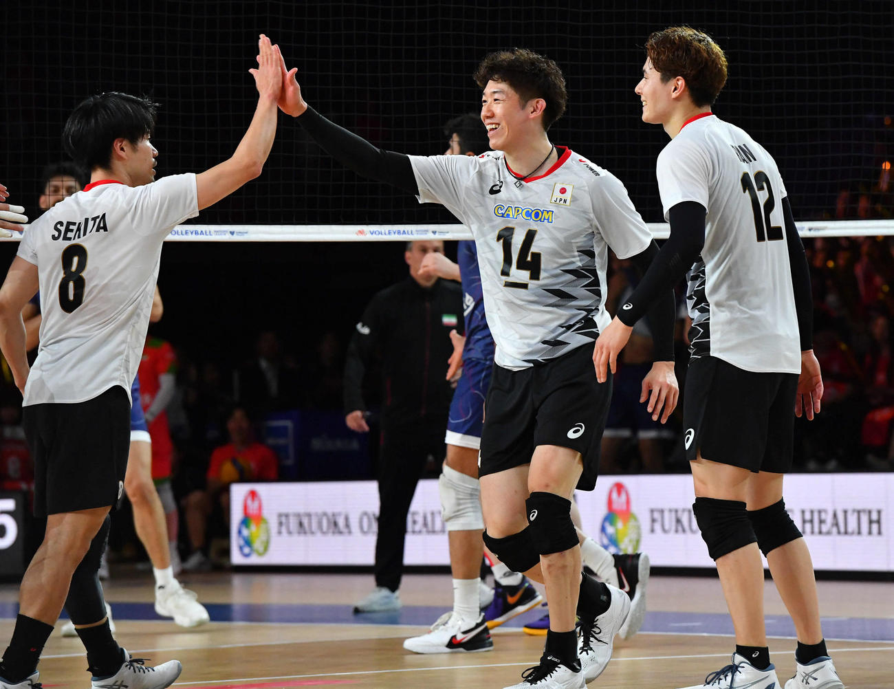 ネーションズリーグ　日本対イラン　第2セット、スパイクで得点し、笑顔でタッチを交わす石川（中央）（撮影・岩下翔太）