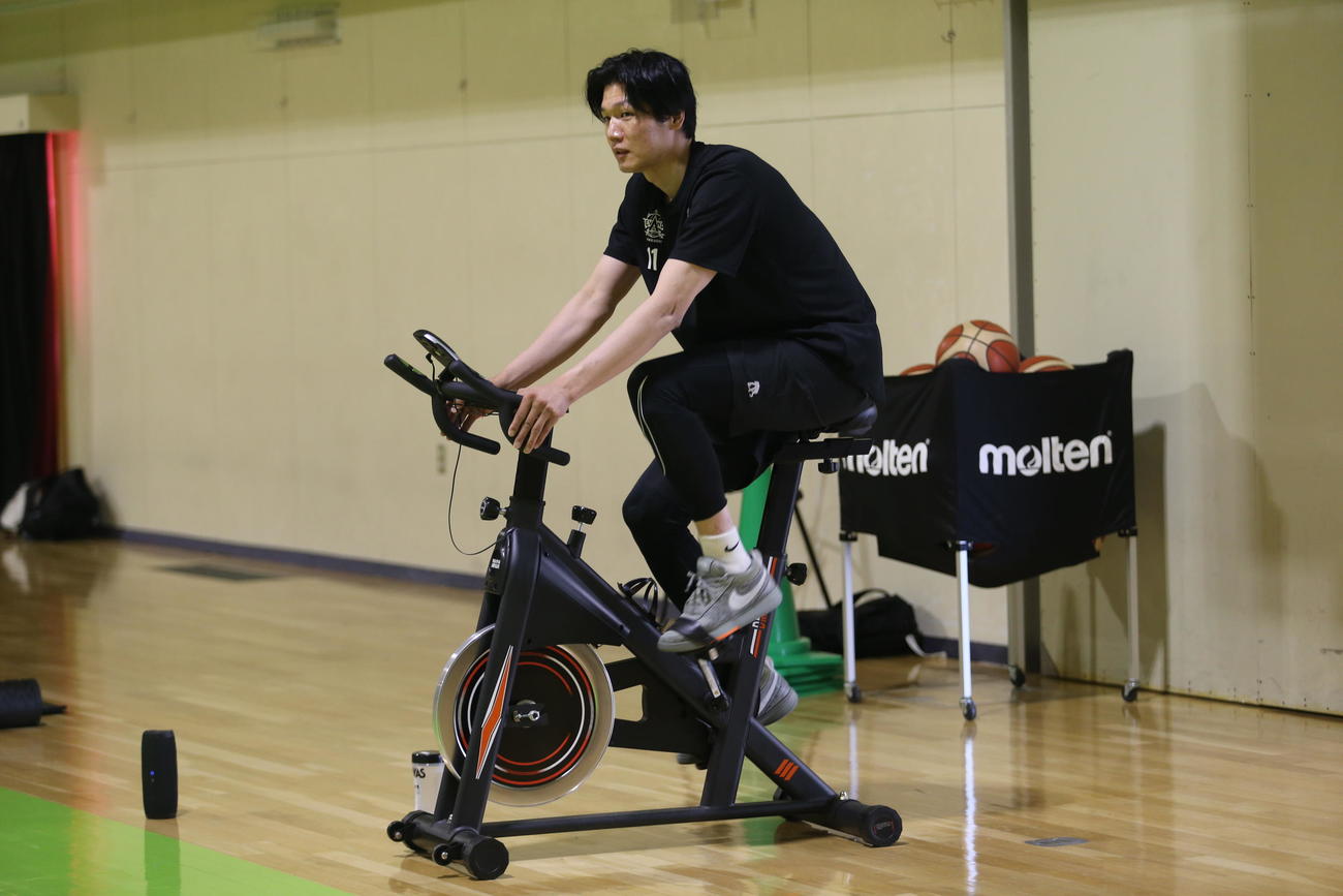 レバンガ北海道の桜井は、トレーニング前に軽く自転車をこぐ（撮影・中島洋尚）