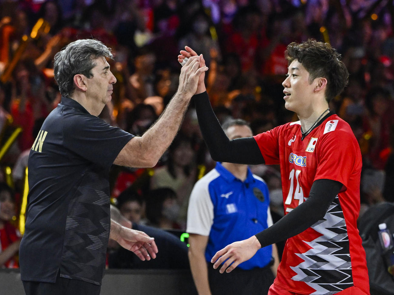 ドイツに勝利し、ブラン監督（左）とタッチを交わす石川（共同）