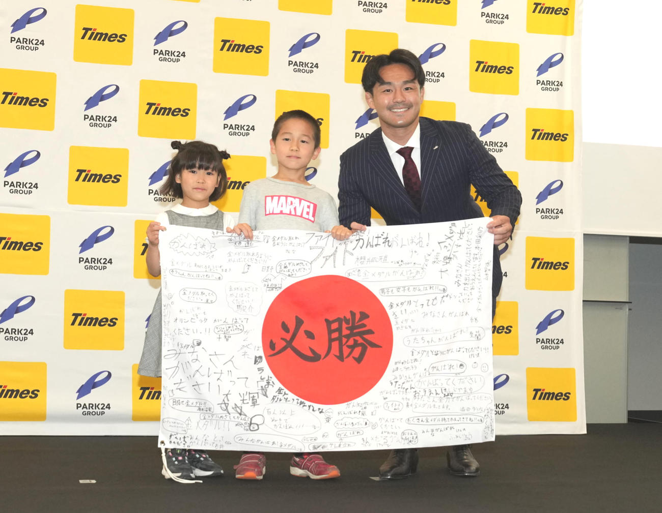 パリ五輪柔道日本代表内定選手壮行会でパーク24が主催する柔道教室の子供たちから激励メッセージが書かれた日の丸を贈呈され、記念撮影する橋本（撮影・小沢裕）