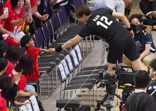 試合後、ファンの子供と握手を交わしてコートを後にする高橋藍
