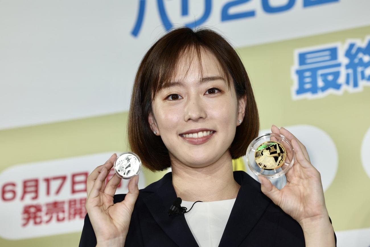 五輪・パラ競技大会パリ2024公式記念コインを手に、笑顔で写真に納まる石川佳純さん（撮影・河田真司）
