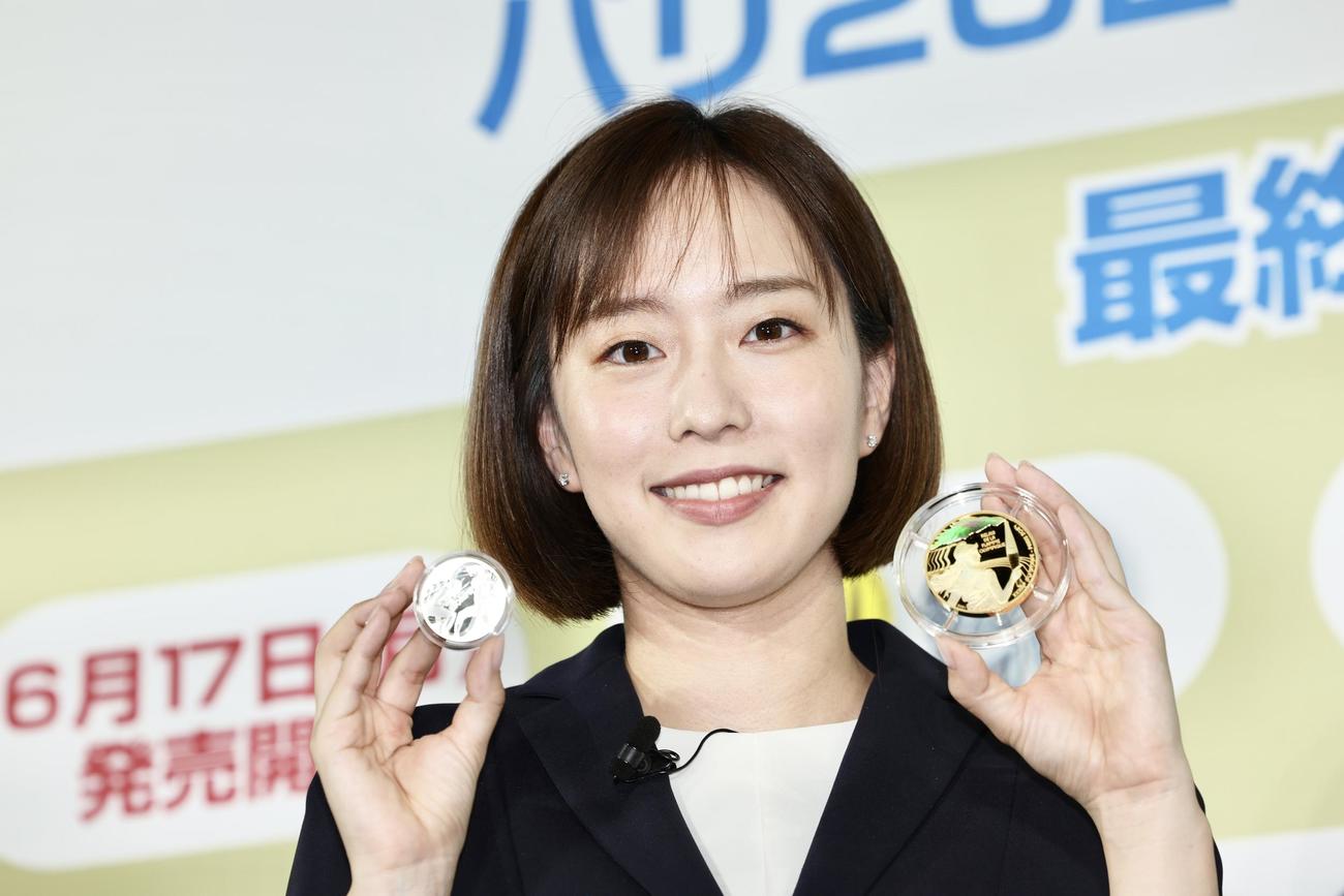 五輪・パラ競技大会パリ2024公式記念コインを手に、笑顔で写真に納まる石川佳純さん（撮影・河田真司）