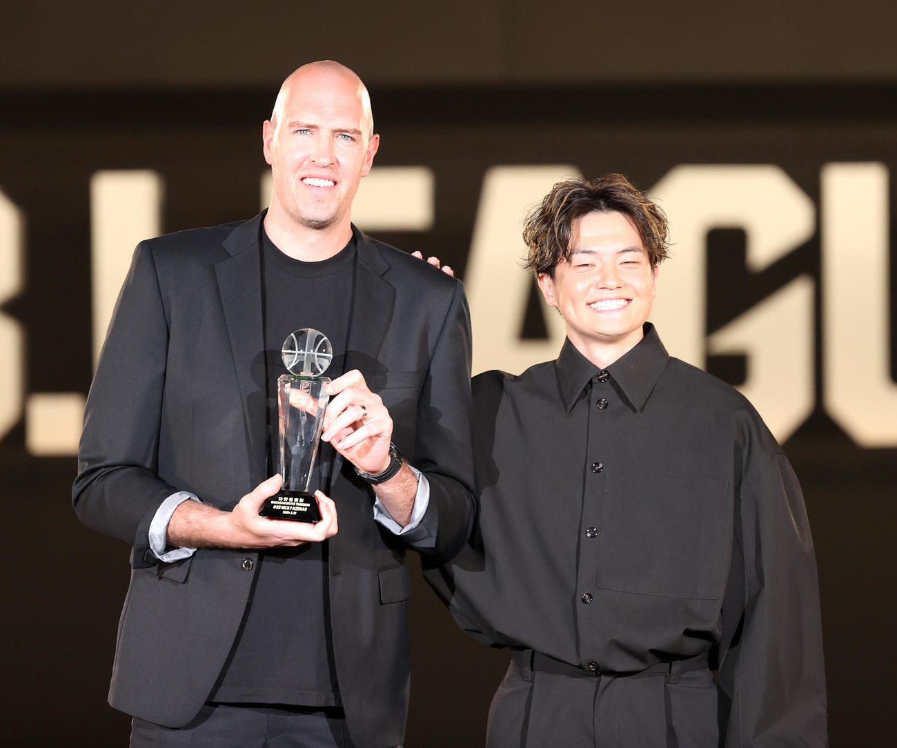 バスケットボール男子Bリーグの年間表彰式「Bリーグアワードショー」　功労賞に輝いた川崎ニック・ファジーカス（左）とプレゼンターの群馬辻直人＝2024年5月31日