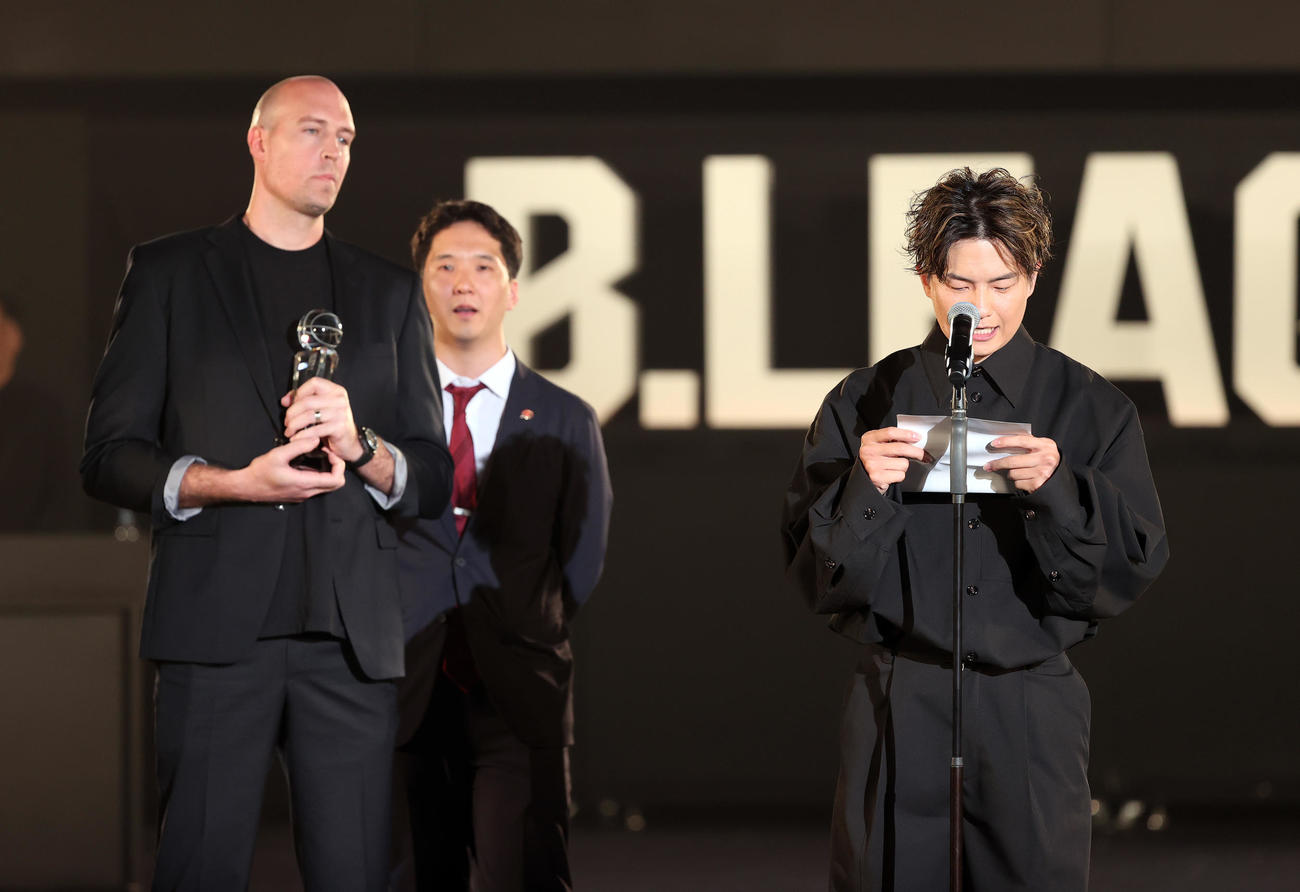 バスケットボール男子Bリーグの年間表彰式「Bリーグアワードショー」　功労賞に輝いた川崎ニック・ファジーカス（左）に贈る手紙を読むプレゼンターの群馬辻直人＝2024年5月31日