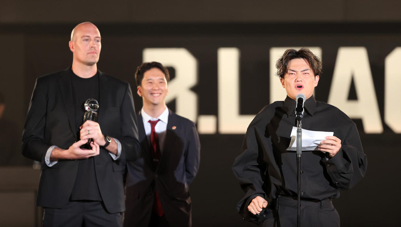 バスケットボール男子Bリーグの年間表彰式「Bリーグアワードショー」　功労賞に輝いた川崎ニック・ファジーカス（左）に贈る手紙を読み、ぐっと涙をこらえるプレゼンターの群馬辻直人＝2024年5月31日