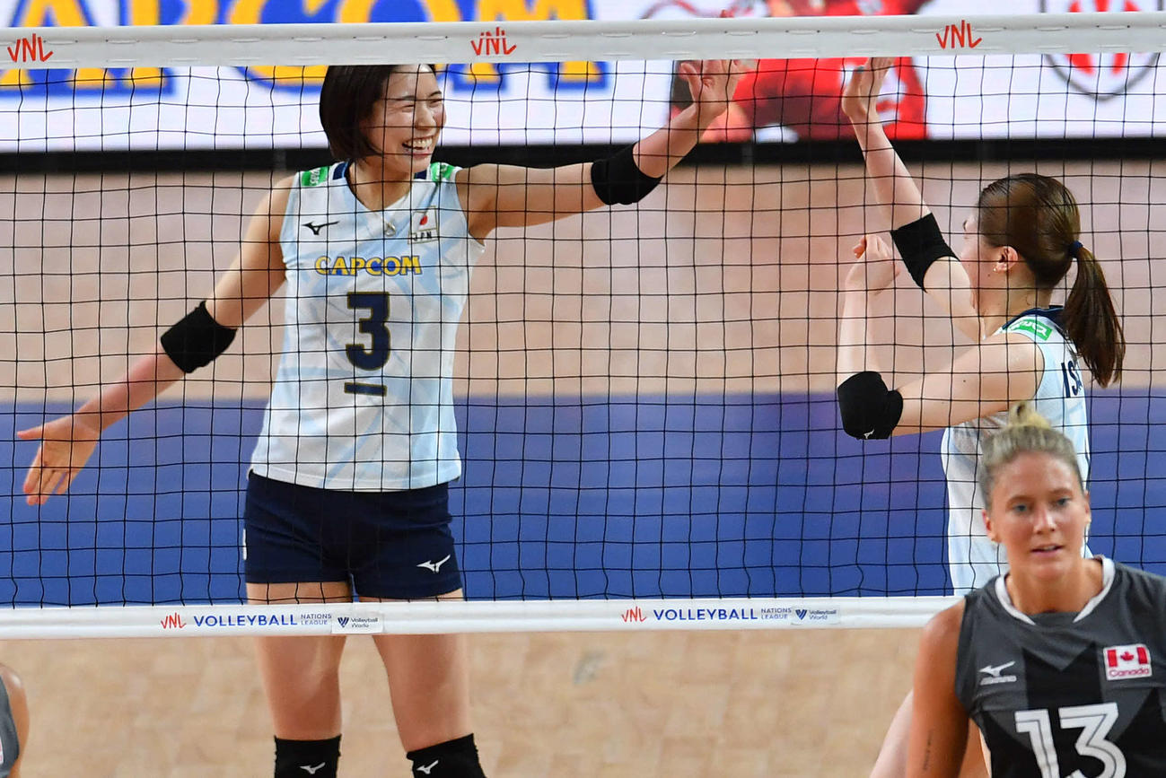 日本対カナダ　第1セット、スパイクで得点を奪った石川（右）と笑顔でタッチを交わす古賀（撮影・岩下翔太）